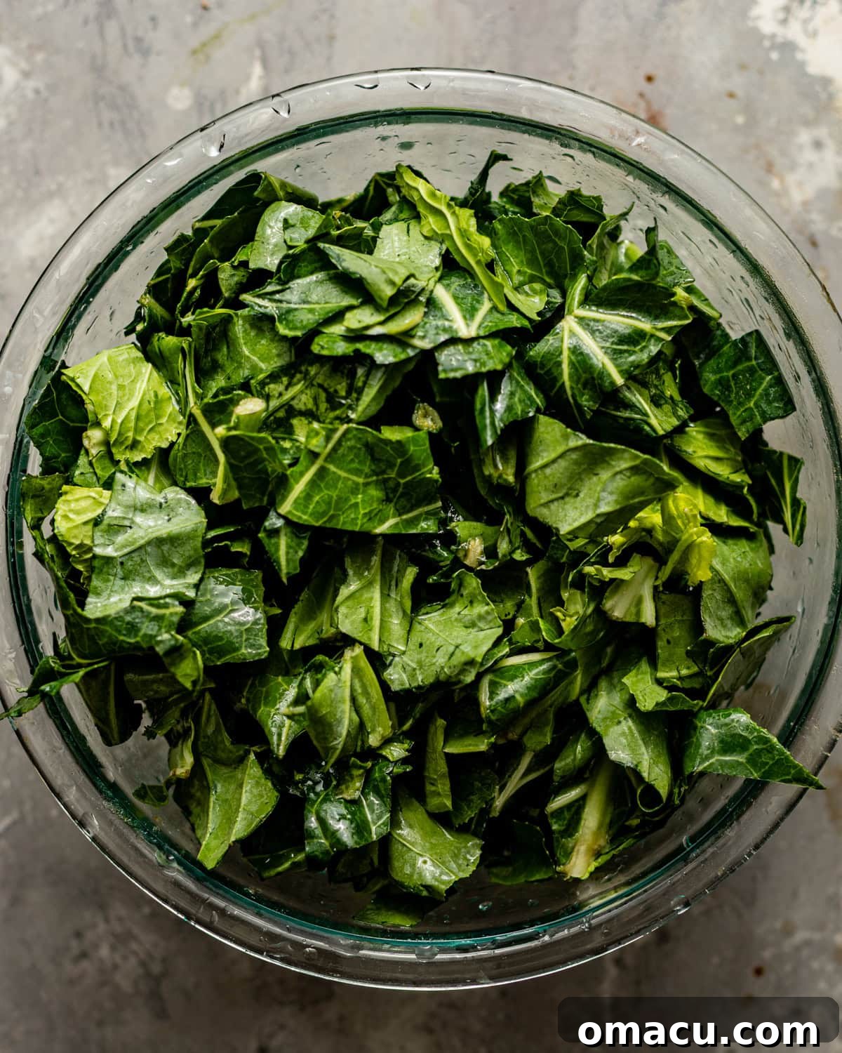 Thoroughly washed and freshly cut collard greens gathered in a large bowl, ready for cooking.