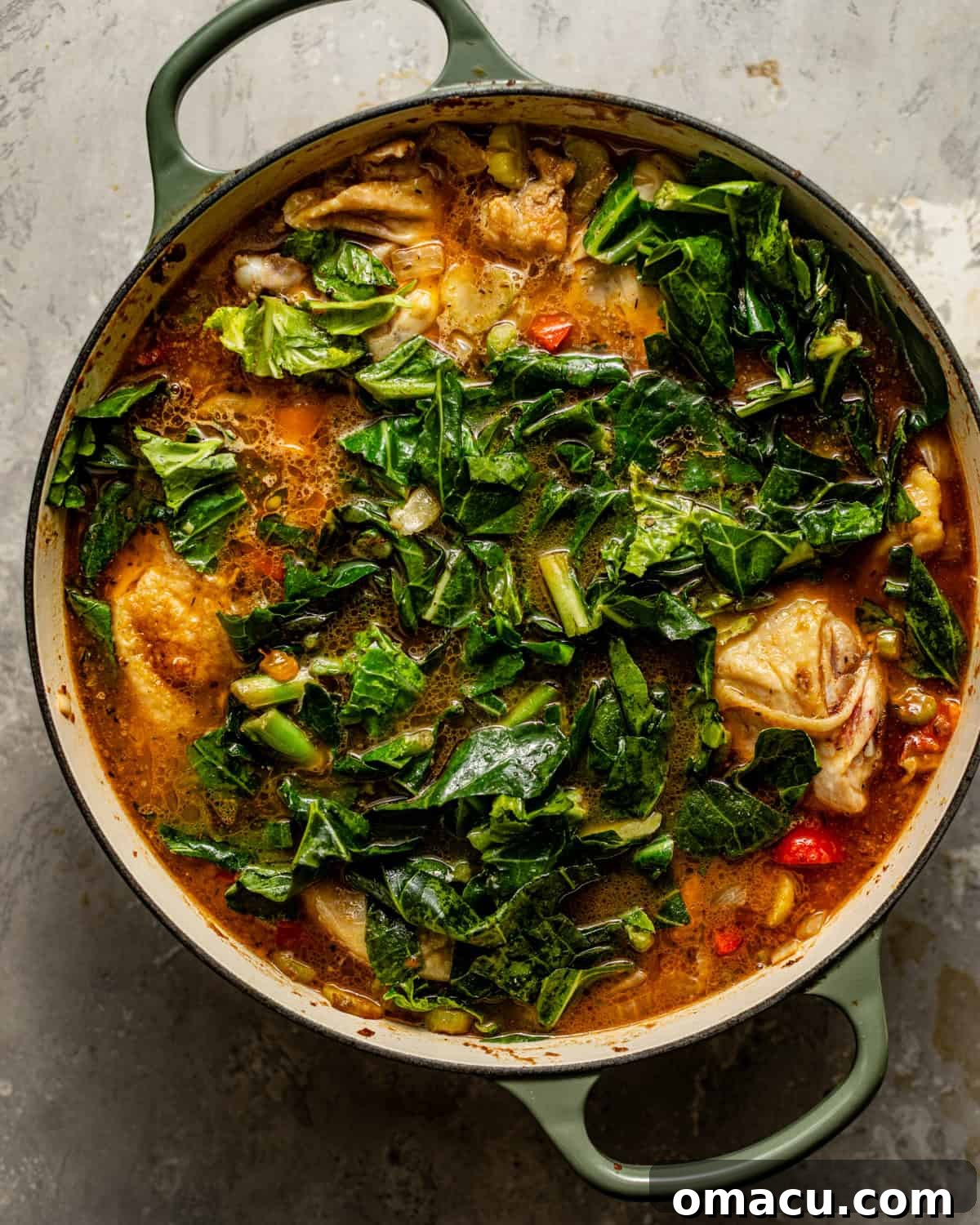 A large pot filled with Gumbo Greens, simmering gently, with tender collard greens and rich broth visible.