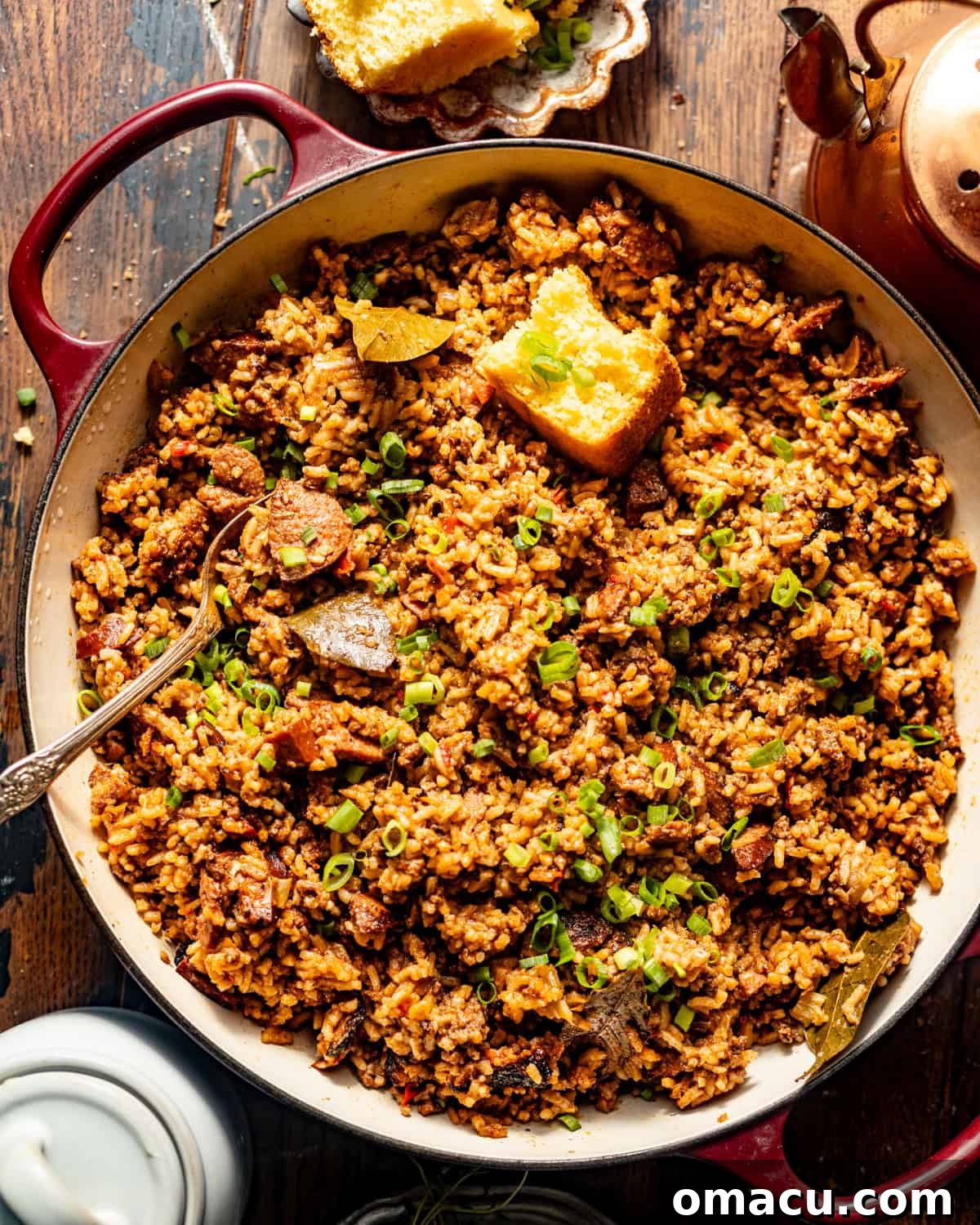 overhead photo of dirty rice in a pot with a piece of cornbread.