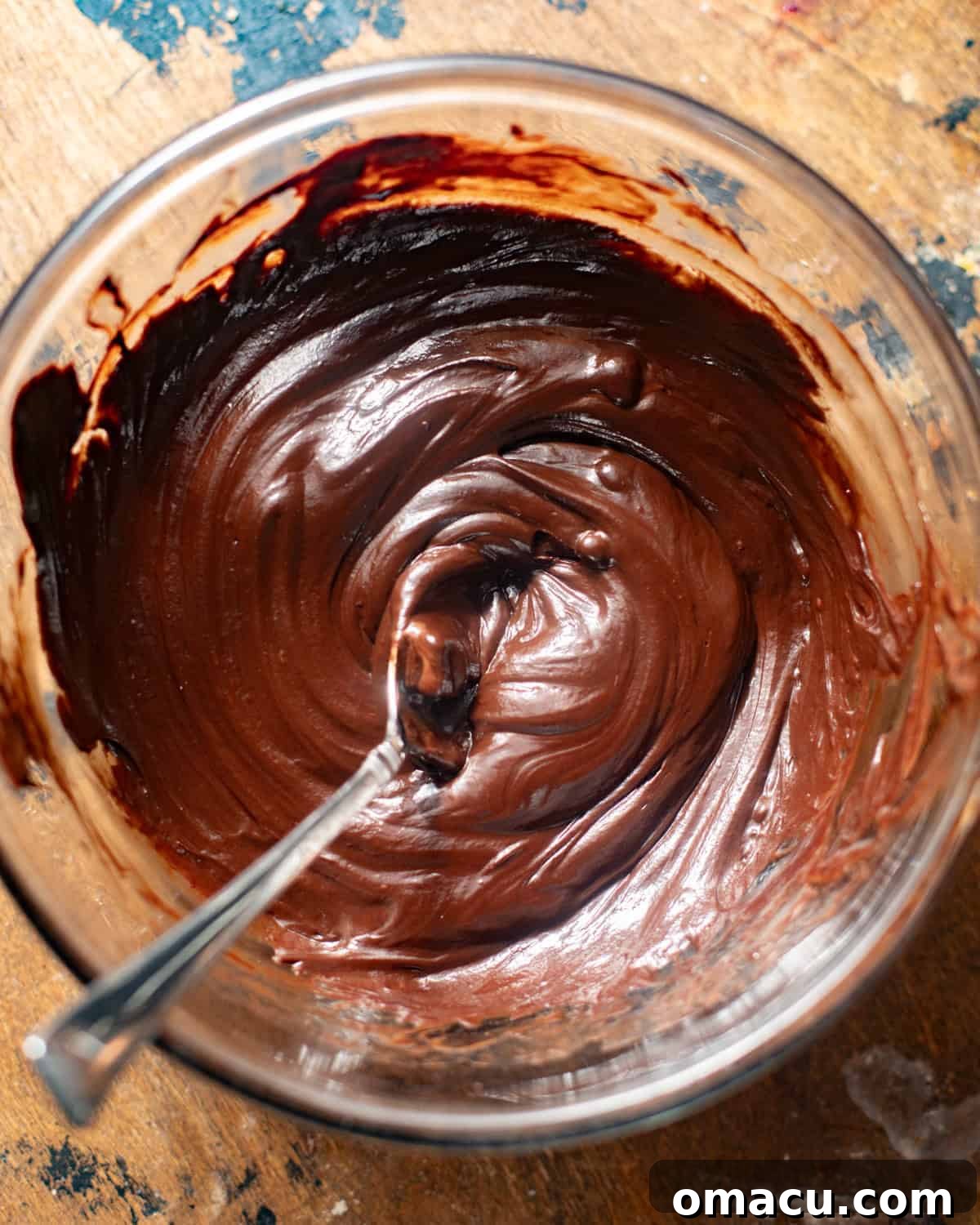 Velvety smooth chocolate ganache resting in a bowl, prepared to top the rich chocolate cake.