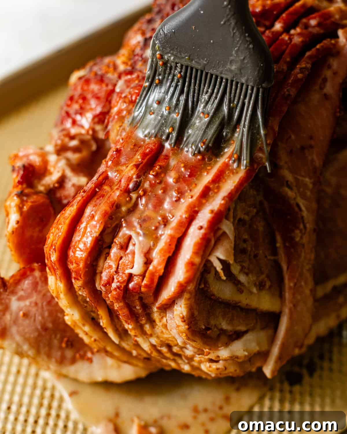 The luscious brown sugar glaze is generously brushed onto the ham, creating a beautiful, sticky coating that will caramelize to perfection.
