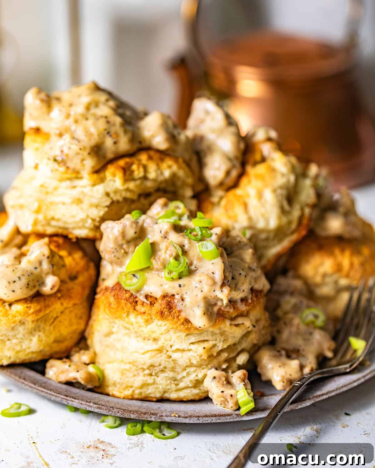 Southern biscuits and gravy on a plate garnished with chopped green onions.