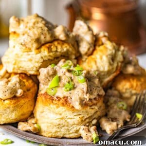 Southern biscuits and gravy on a plate garnished with chopped green onions.