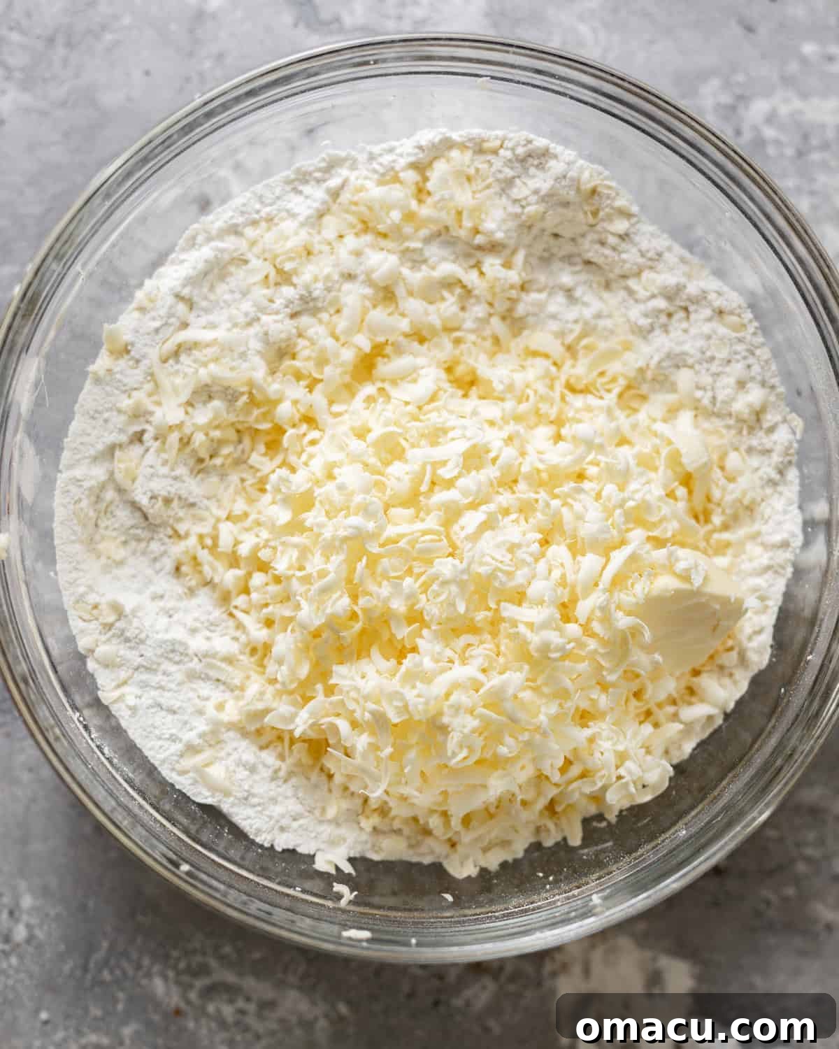 Cold butter grated into the dry ingredients in a mixing bowl.