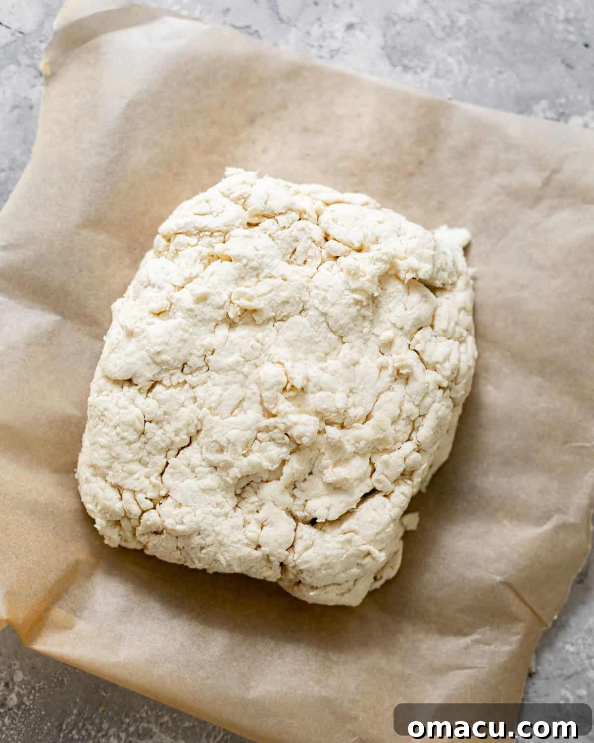 Biscuit dough on a piece of parchment paper.