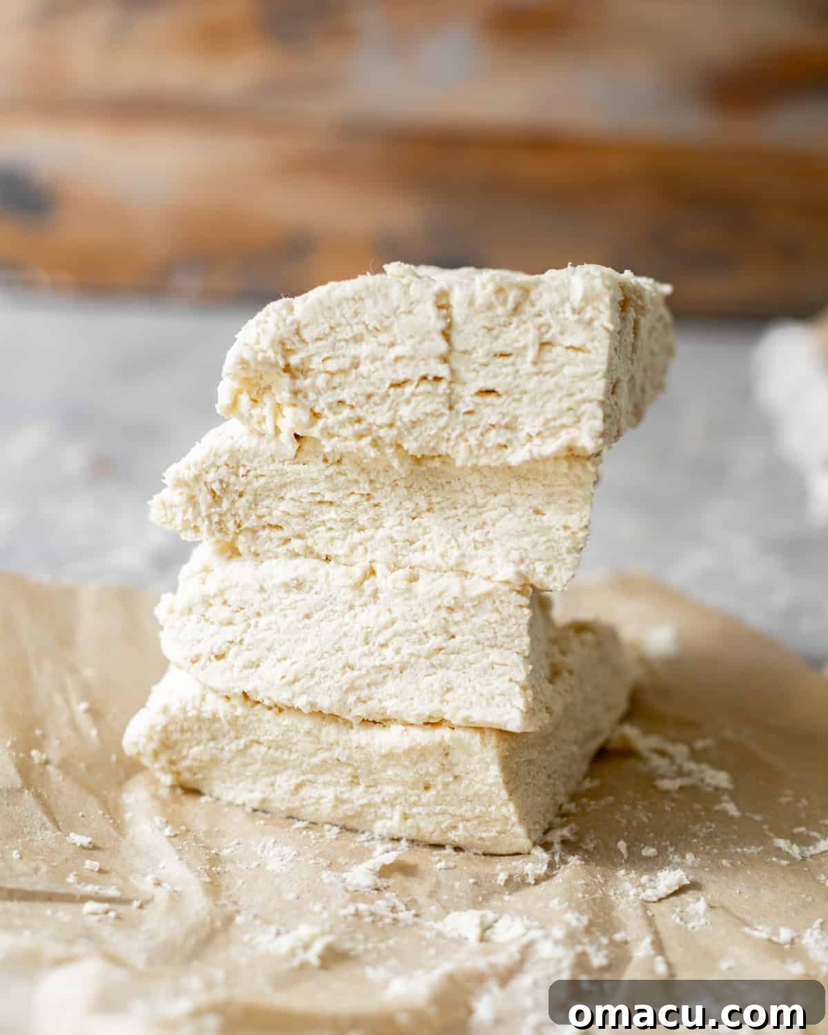 Biscuit dough cut into 4 pieces and stacked on top of each other to create the flaky biscuit layers.