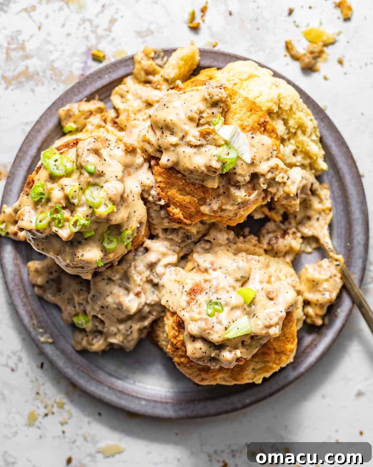 Overhead photo of biscuits and gravy on a plate with a fork.