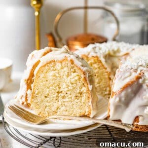 A slice of perfect coconut pound cake on a plate, showcasing the fluffy interior and delightful crunch glaze.