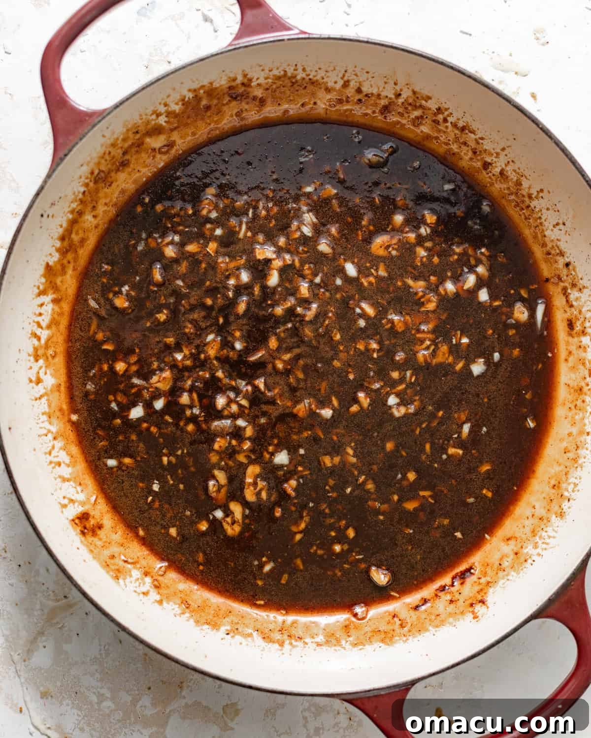 Honey garlic sauce simmering in a pan until it has slightly thickened and become glossy.