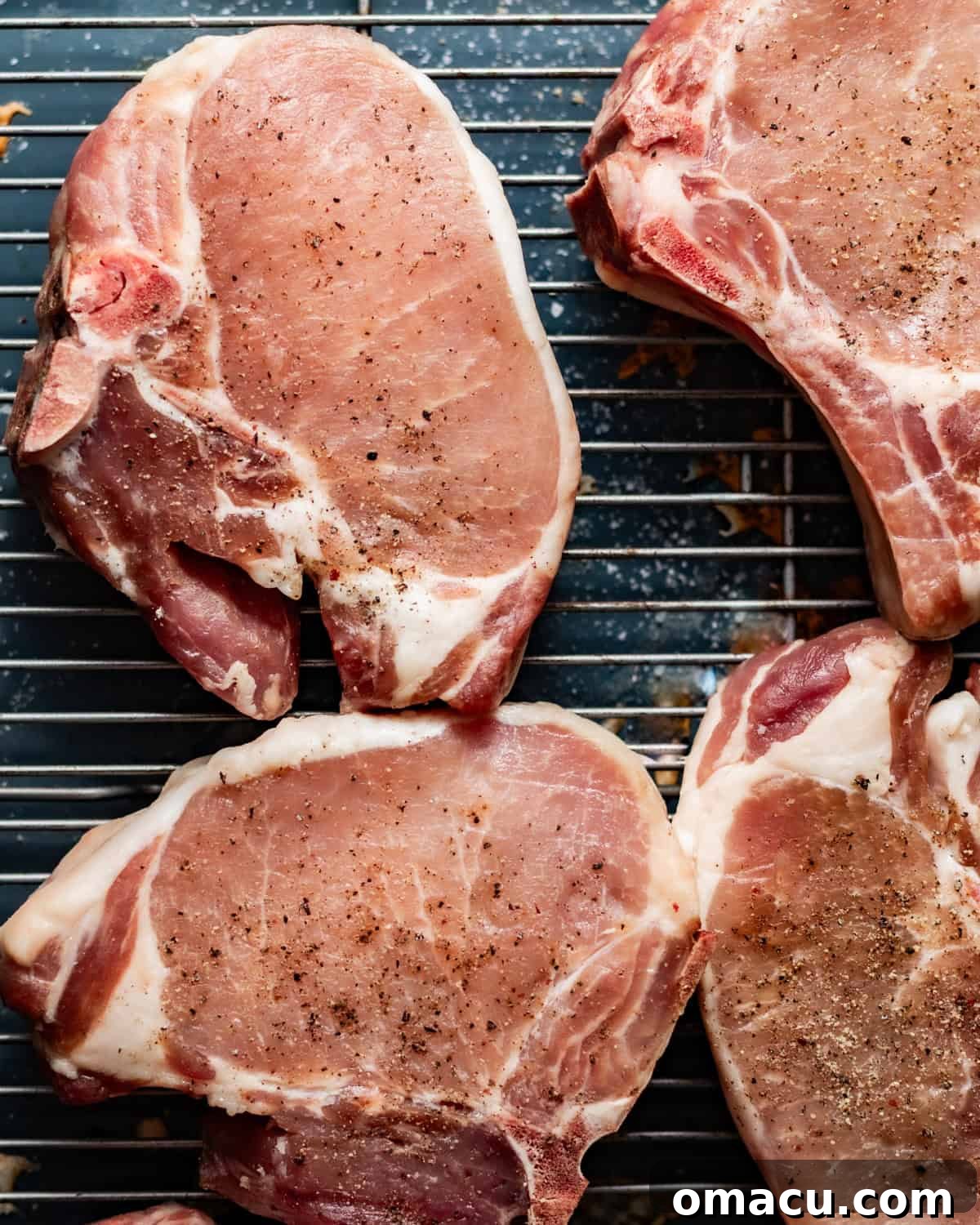 seasoned pork chops on a wire rack. 