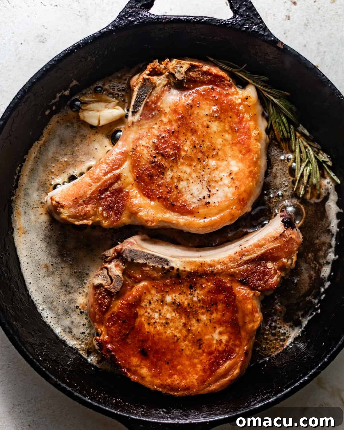 seared pork chops in a cast iron skillet.