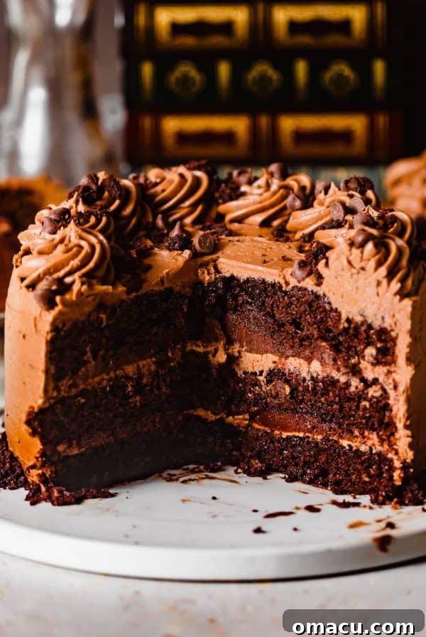 triple chocolate cake on a white plate with a large piece cut out to show the inside of the cake.