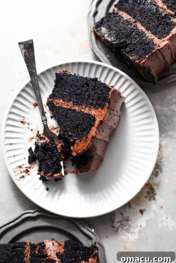 sliced chocolate cake on small plates with forks.