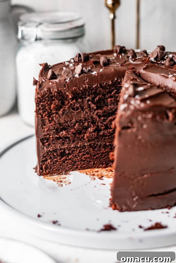 chocolate ganache cake sliced on a cake plate to see the interior of the cake.