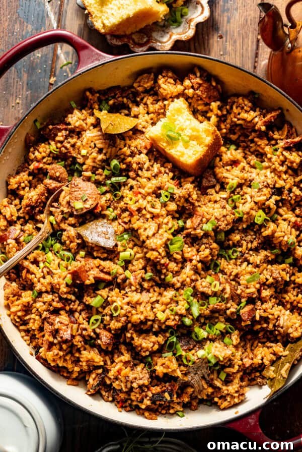 overhead photo of dirty rice in a pot with a piece of cornbread.
