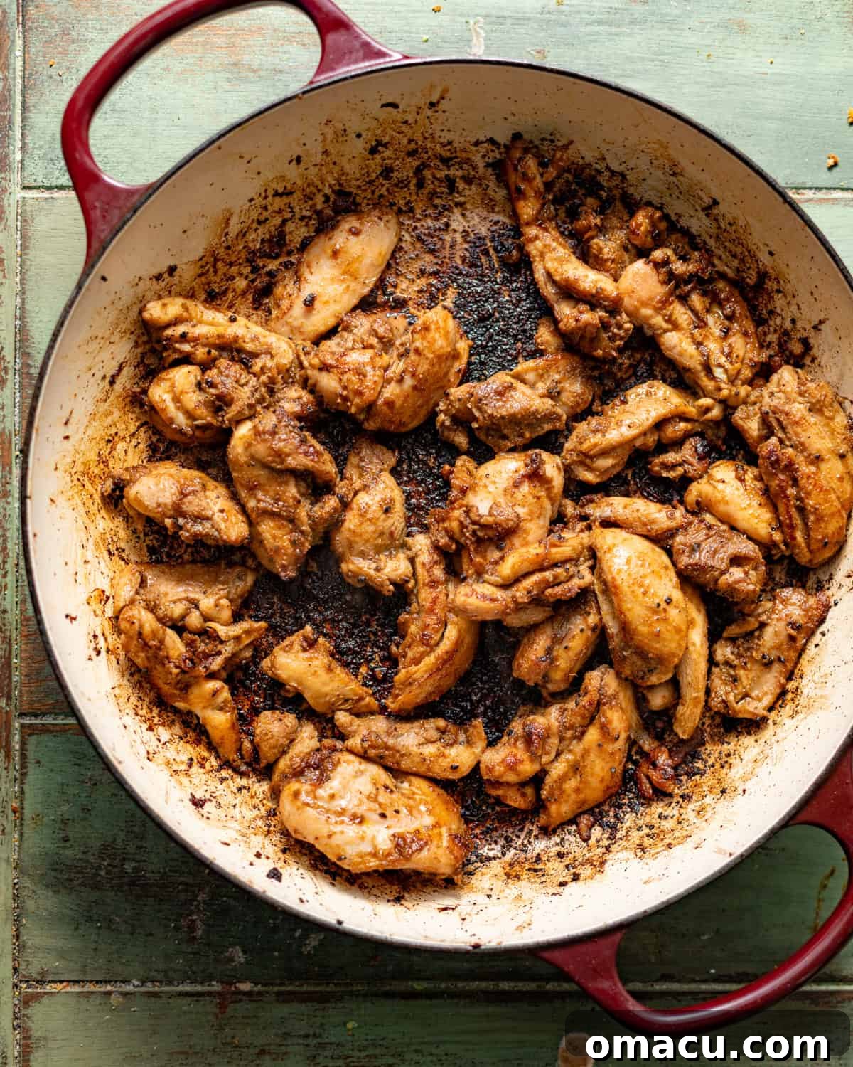 seared marinated jerk chicken in a skillet.