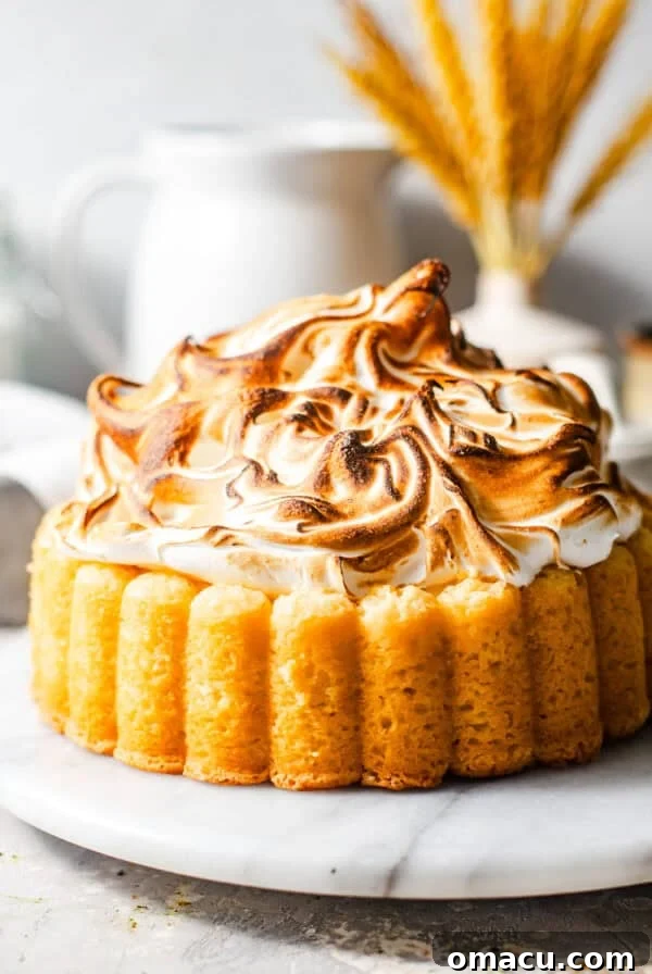 lemon meringue cake on a serving plate topped with torched meringue.