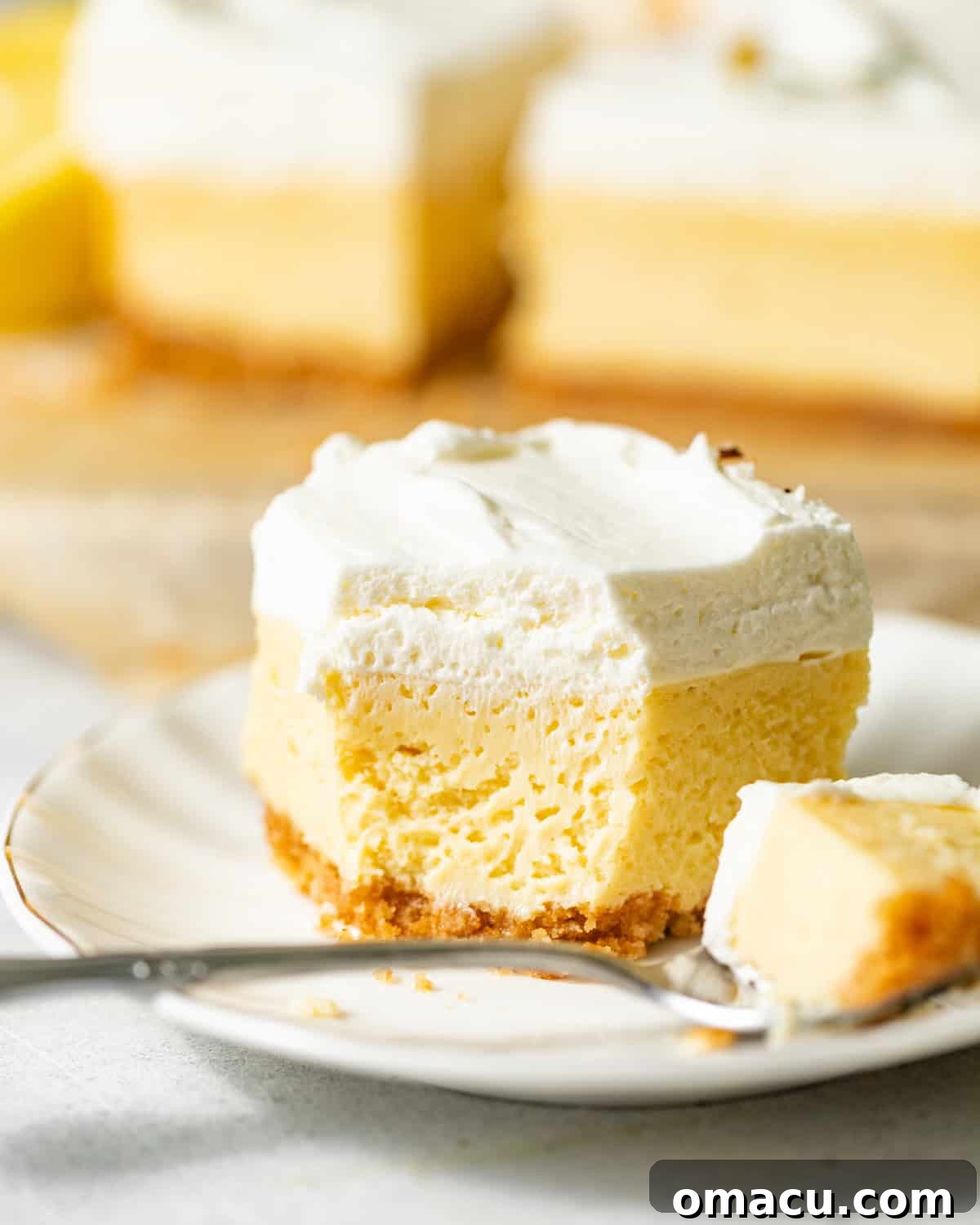 lemon bars on a plate with a spoon. 