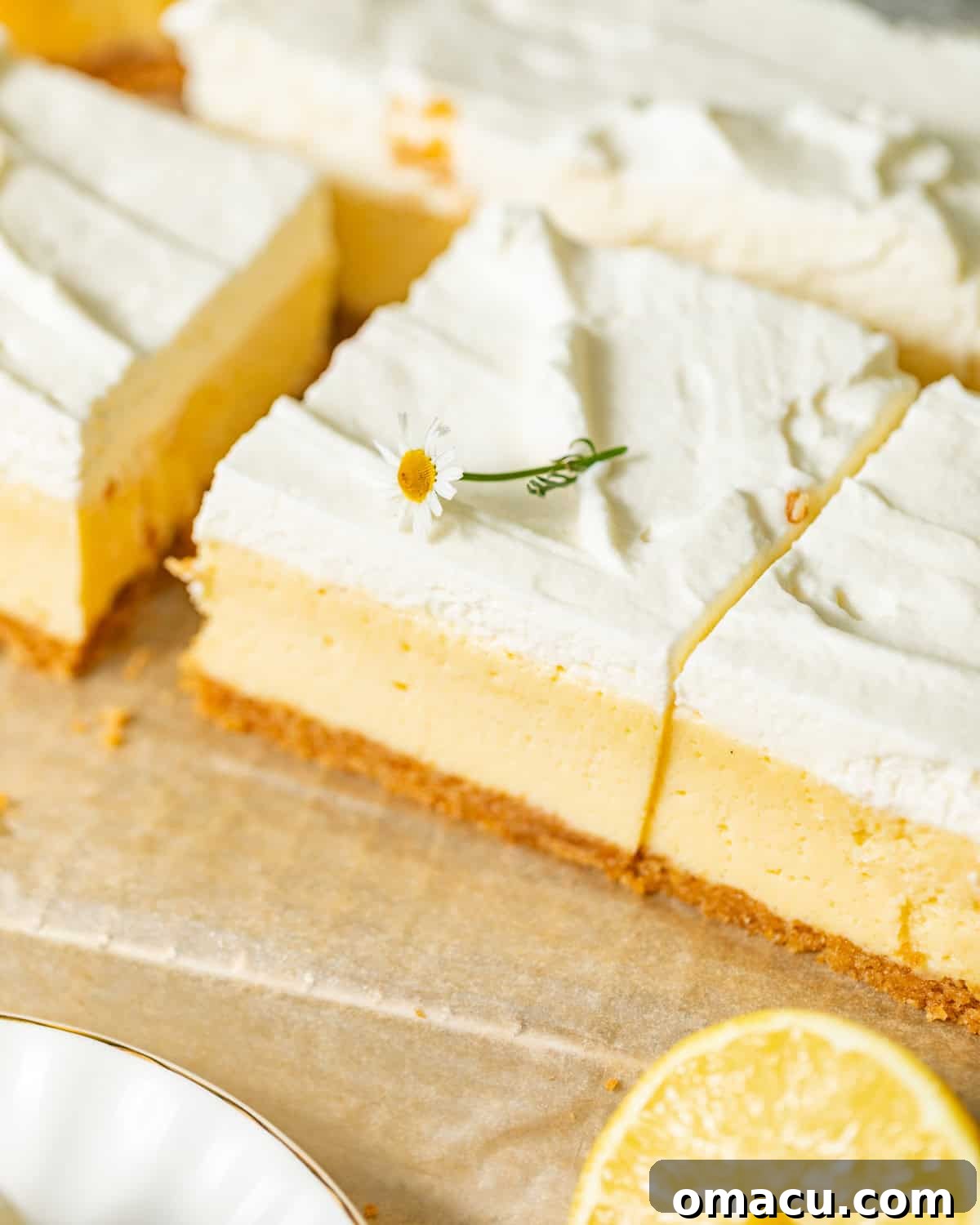 lemon bars on parchment paper cut into slices.