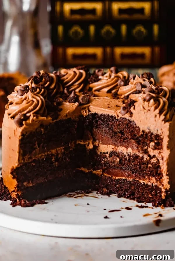triple chocolate cake on a white plate with a large piece cut out to show the inside of the cake.
