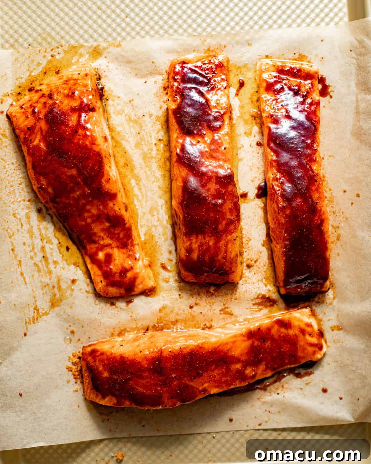 salmon on a baking sheet topped with the bbq sauce glaze.