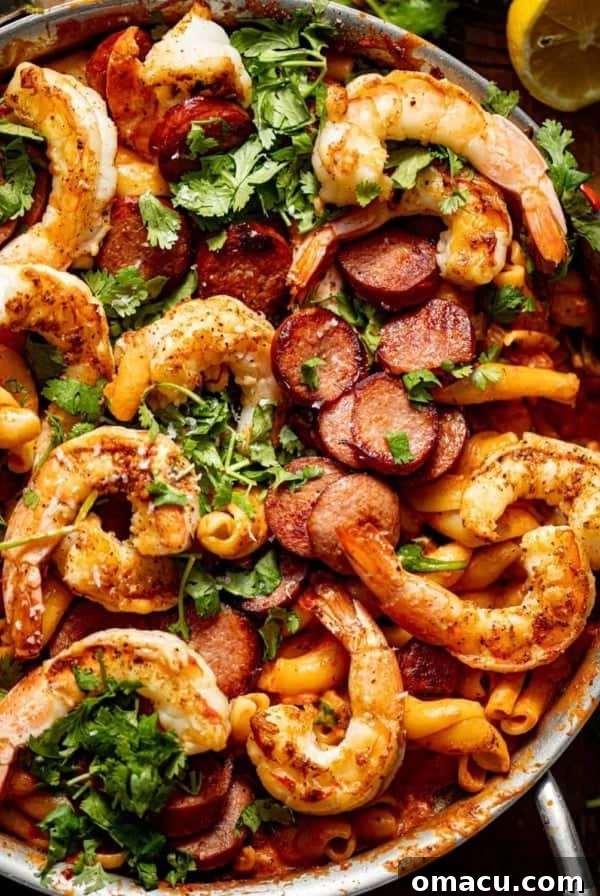 up close photo of cajun shrimp and sausage pasta in a pan.
