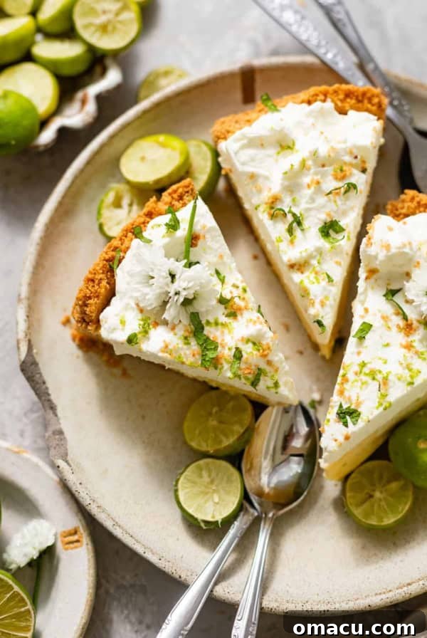 Strawberry Shortcake Recipe: Classic Layer Cake with Fresh Berries 12 sliced key lime pie on a ceramic plate with fresh key limes, edible flowers, and serving spoons.