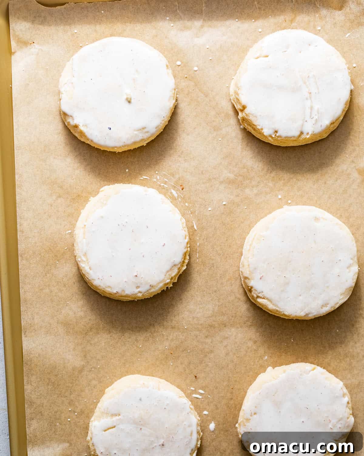 Strawberry Shortcake Recipe: Classic Layer Cake with Fresh Berries 8 biscuits on a parchment paper lined baking sheet brushed with heavy cream and sugar sprinkled on top before baking.