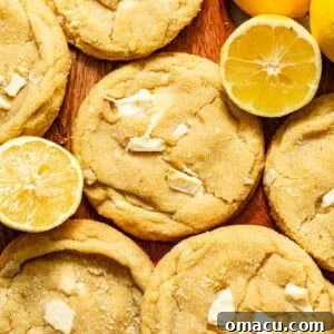 Zesty Lemon White Chocolate Chip Cookie Recipe 13 lemon white chocolate cookies on a board with sliced lemons.