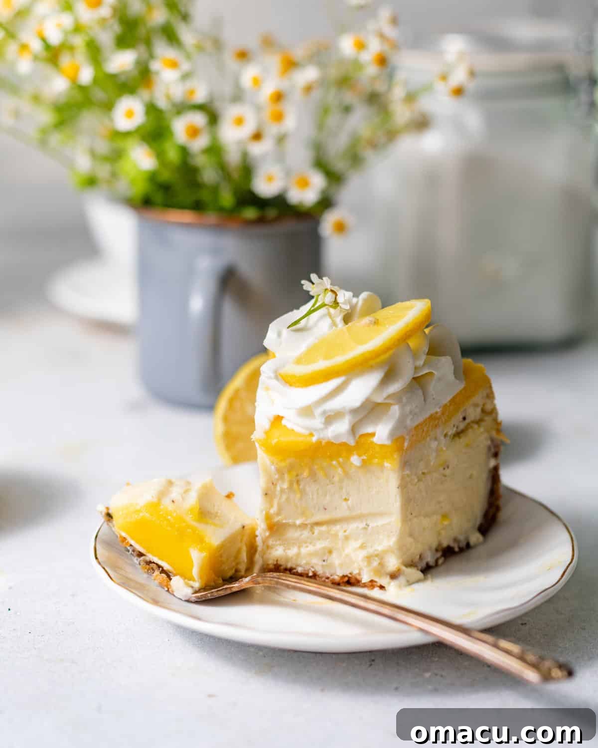 Creamy Lemon Cheesecake Topped with Zesty Lemon Curd 3 a slice of lemon cheesecake on a plate with a fork.