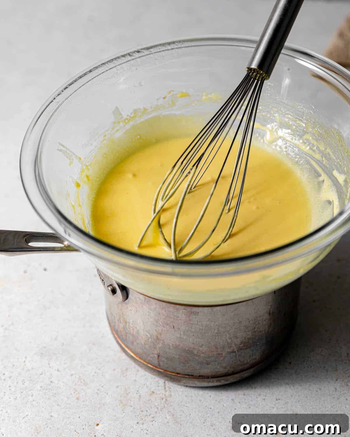 Creamy Lemon Cheesecake Topped with Zesty Lemon Curd 8 lemon curd on a double boiler with a whisk.