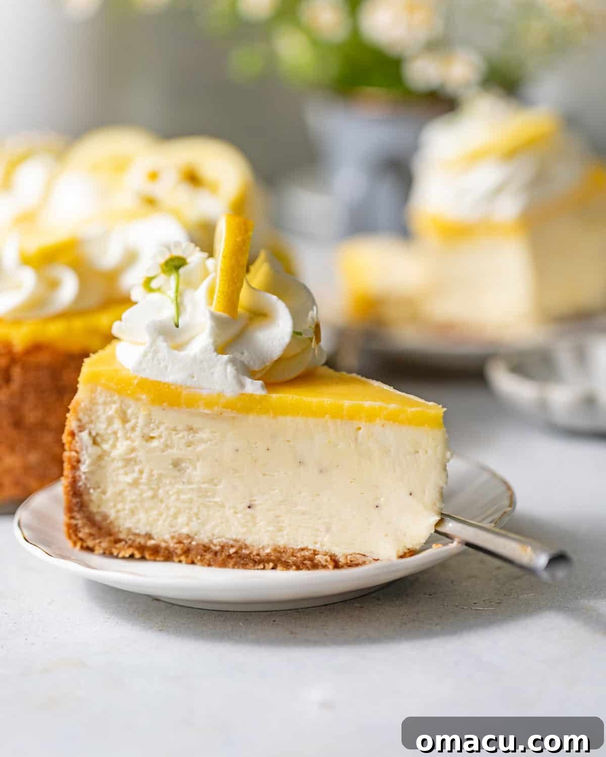 Creamy Lemon Cheesecake Topped with Zesty Lemon Curd 9 a slice of lemon cheesecake on a small cake plate.