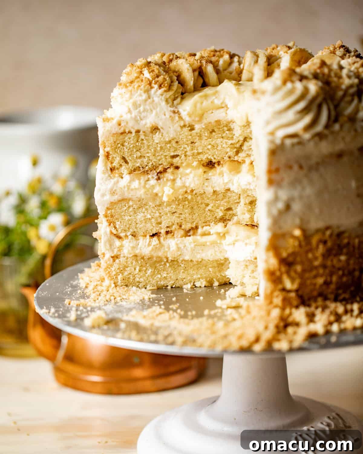 sliced banana pudding layer cake on a cake stand.