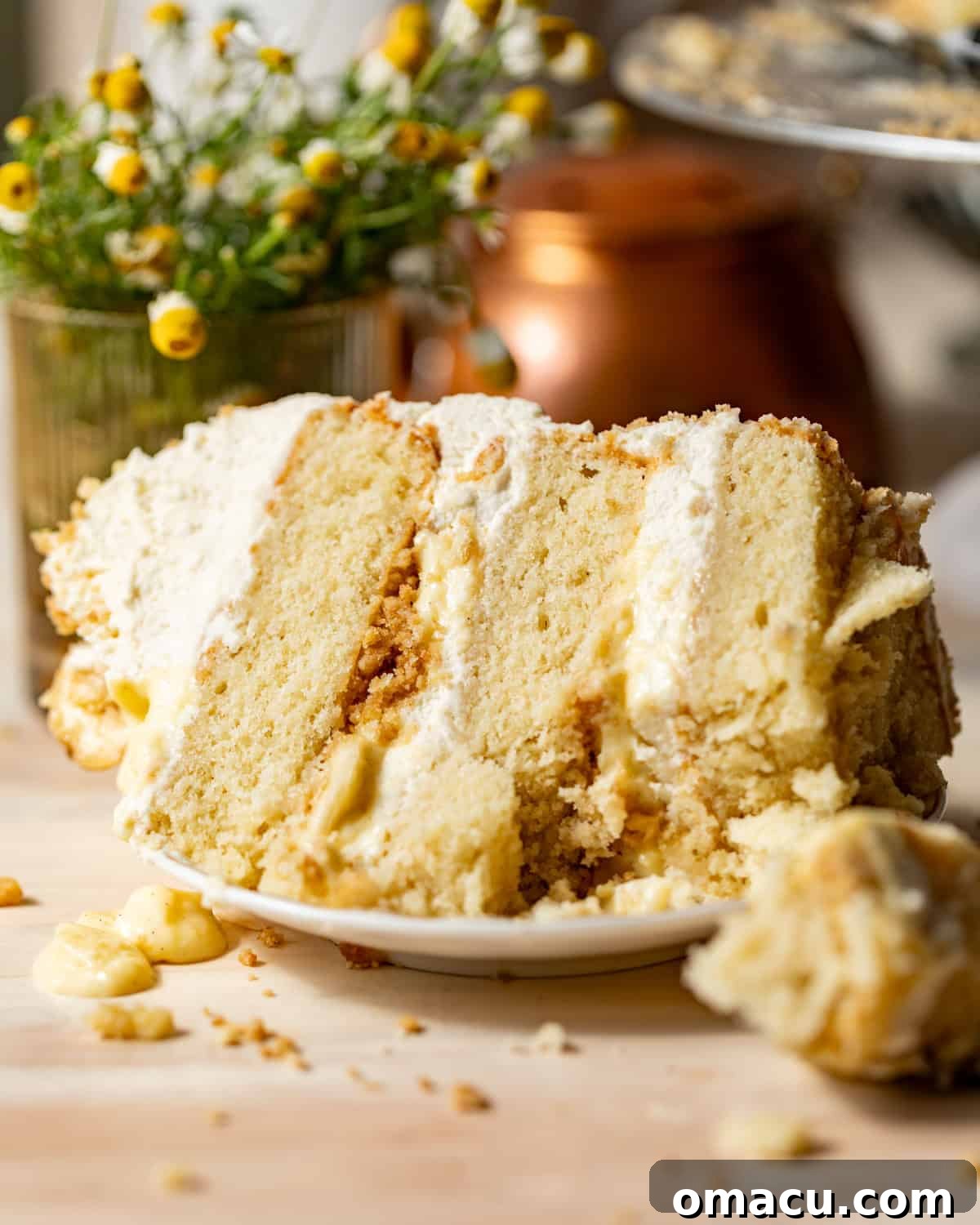 a slice of banana pudding cake on a cake plate with a fork taking a bite out of the cake.