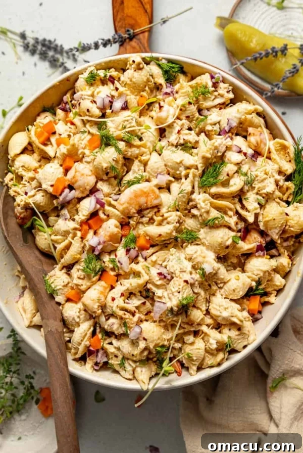 Oven-Baked Corn on the Cob with Garlic Herb Butter 10 seafood pasta salad in a bowl with a spoon on top of a serving board.