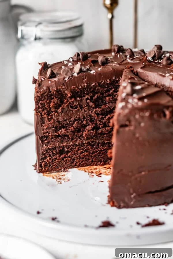 chocolate ganache cake sliced on a cake plate to see the interior of the cake.