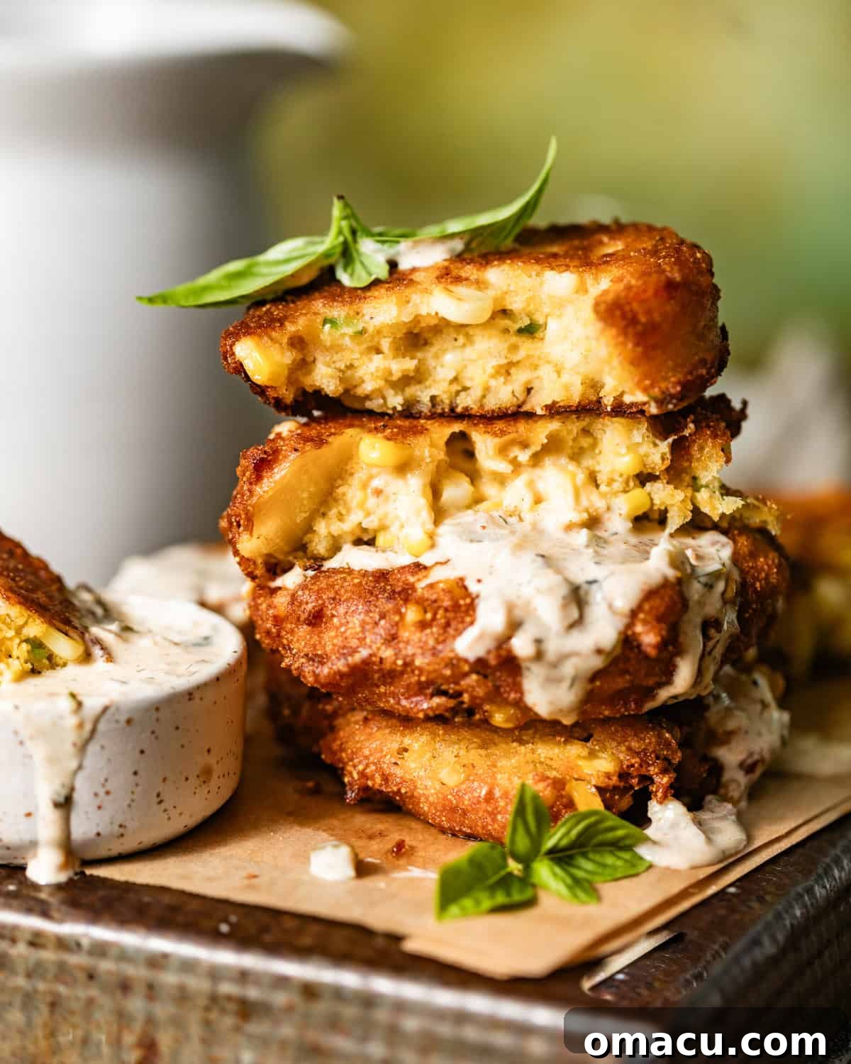 corn fritters stacked on top of each other on a serving tray.