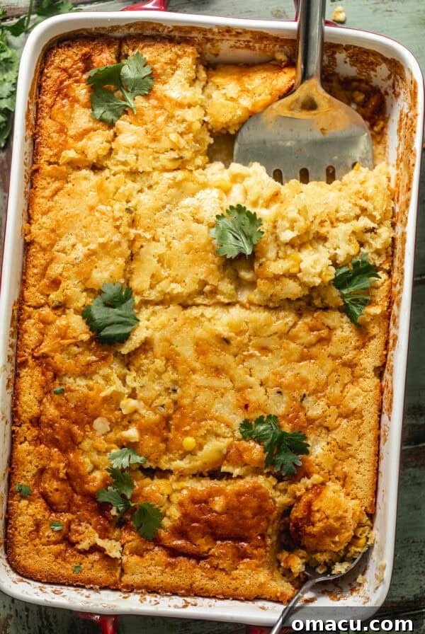 cornbread pudding in a baking dish garnished with parsley.