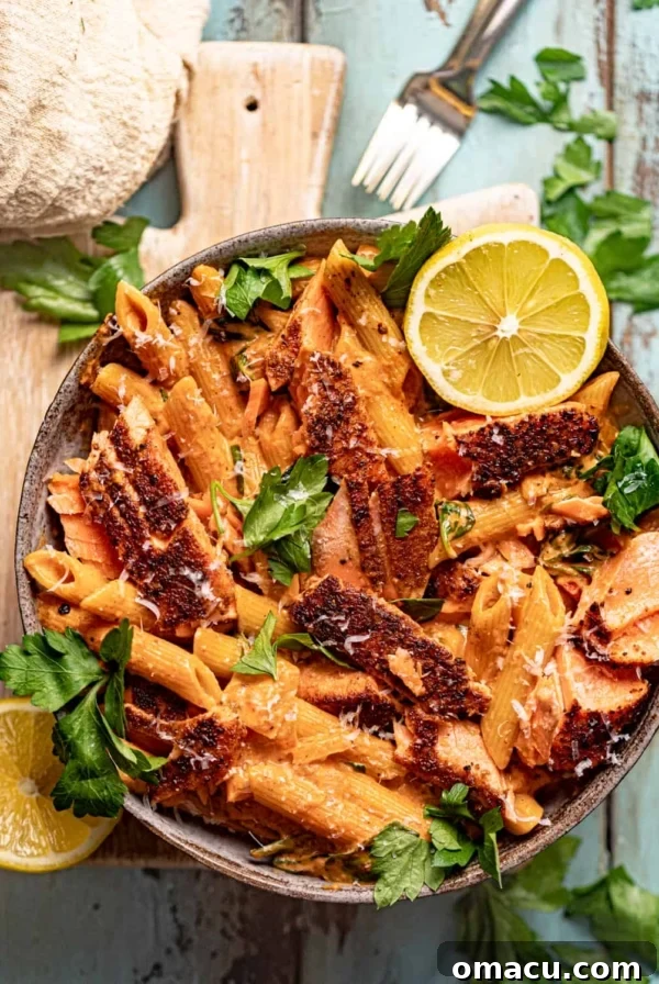 cajun salmon pasta in a bowl on top of a serving board.
