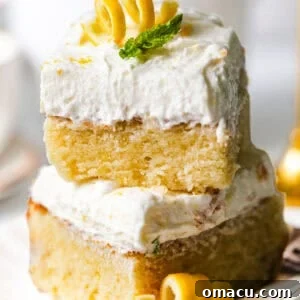 Moist Lemon Sheet Cake Recipe with Zesty Glaze 9 lemon sheet cake slices stacked on top of each other topped with lemon curls and a fresh mint leaf for garnish.