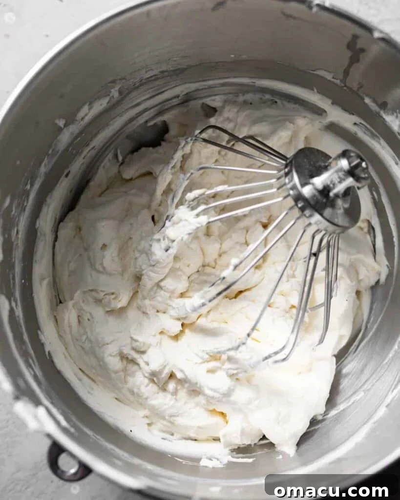 Moist Lemon Sheet Cake Recipe with Zesty Glaze 7 lemon cream cheese frosting mixed together in the bowl of a stand mixer.