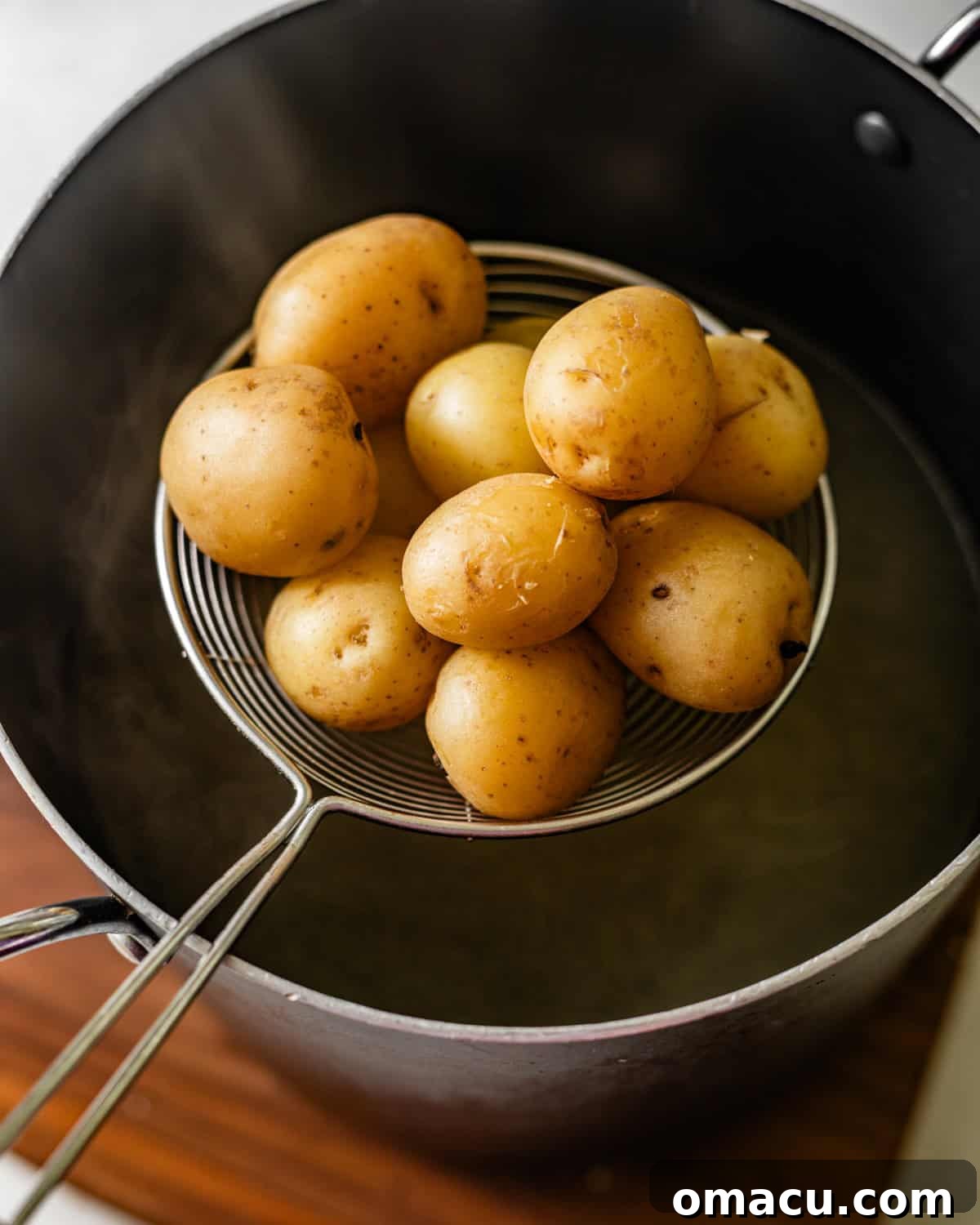 Crispy Garlic Parmesan Smashed Potatoes 4 cooking baby potatoes coming out of a pot of boiling water.