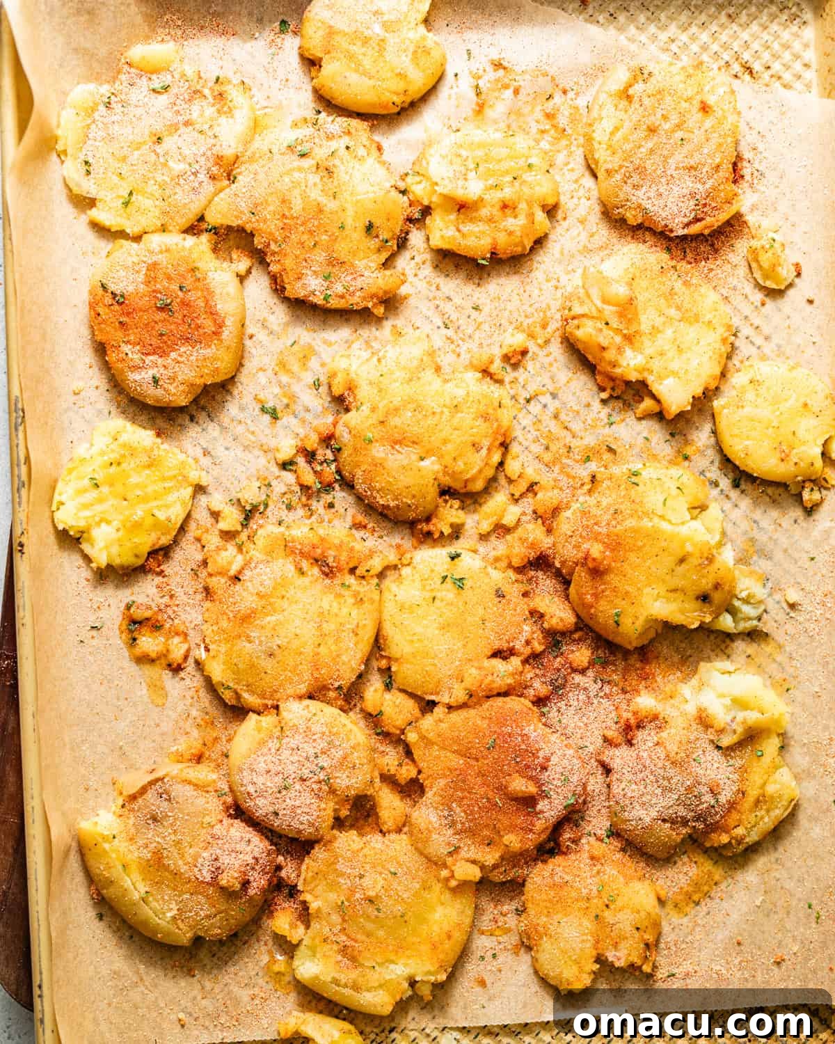 Crispy Garlic Parmesan Smashed Potatoes 6 baby potatoes smashed on a baking sheet and drizzled with olive oil and seasonings.