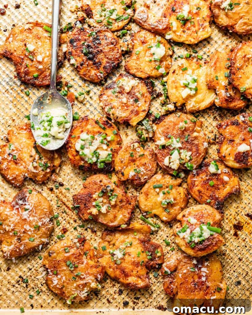 Crispy Garlic Parmesan Smashed Potatoes 7 garlic butter poured on top of the smashed potatoes on a baking sheet.