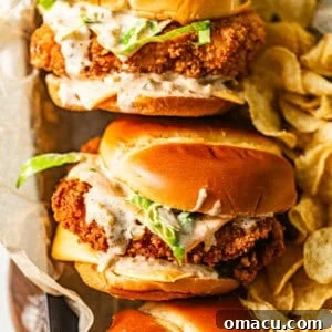 fried fish sandwiches in a serving tray with a side of potato chips.