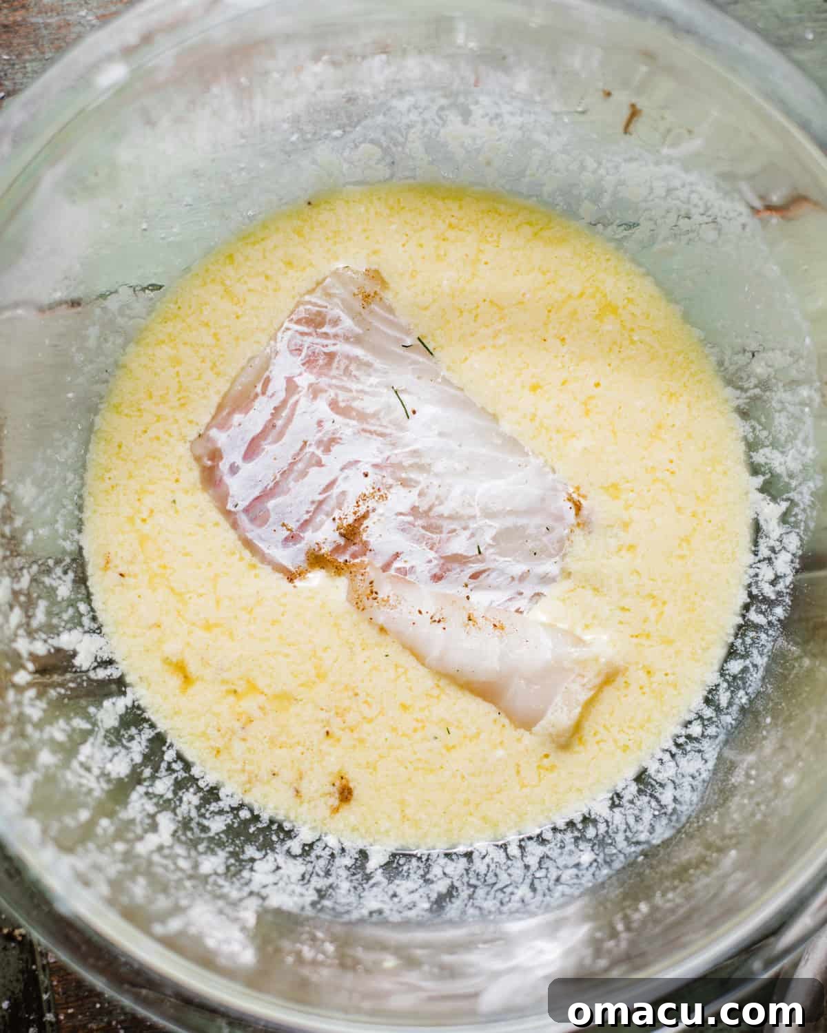 cod in a bowl with buttermilk, eggs, and seasonings.