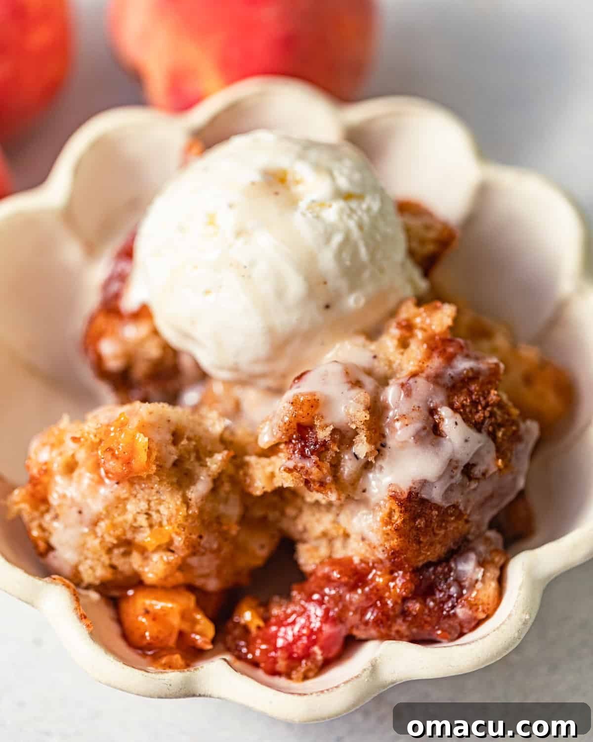 Skillet Peach Fritter Cake with Vanilla Bean Glaze 3 peach fritter cake in a bowl with a scoop of ice cream on top.