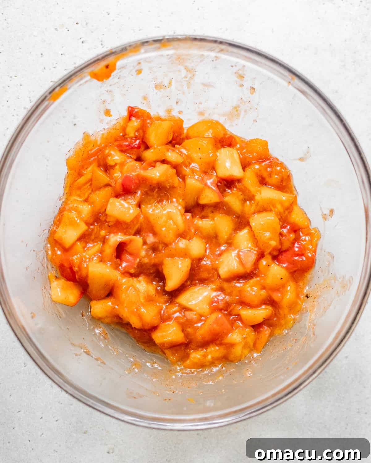 Skillet Peach Fritter Cake with Vanilla Bean Glaze 4 cooked peach cake filling in a bowl.