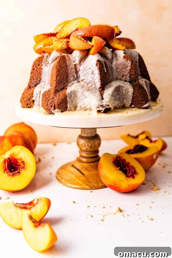 Skillet Peach Fritter Cake with Vanilla Bean Glaze 8 pound cake on a cake stand topped with roasted peaches.