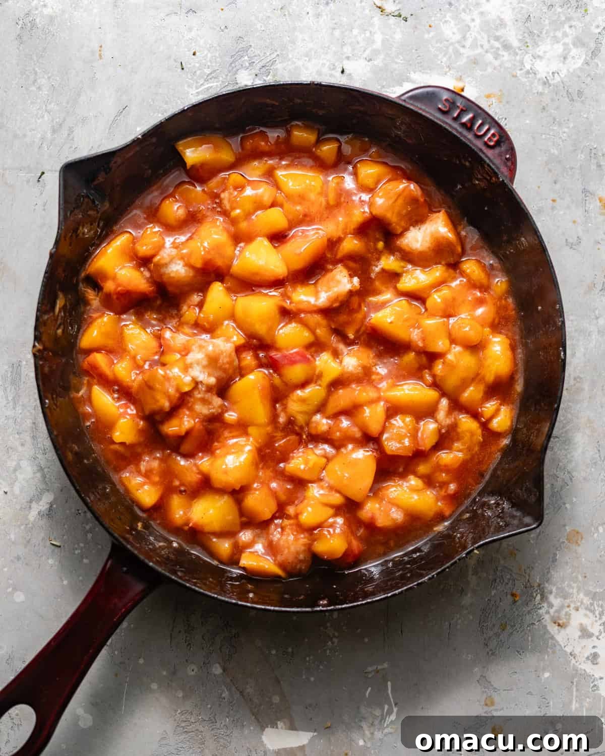 peach cobbler filling cooked in a skillet.